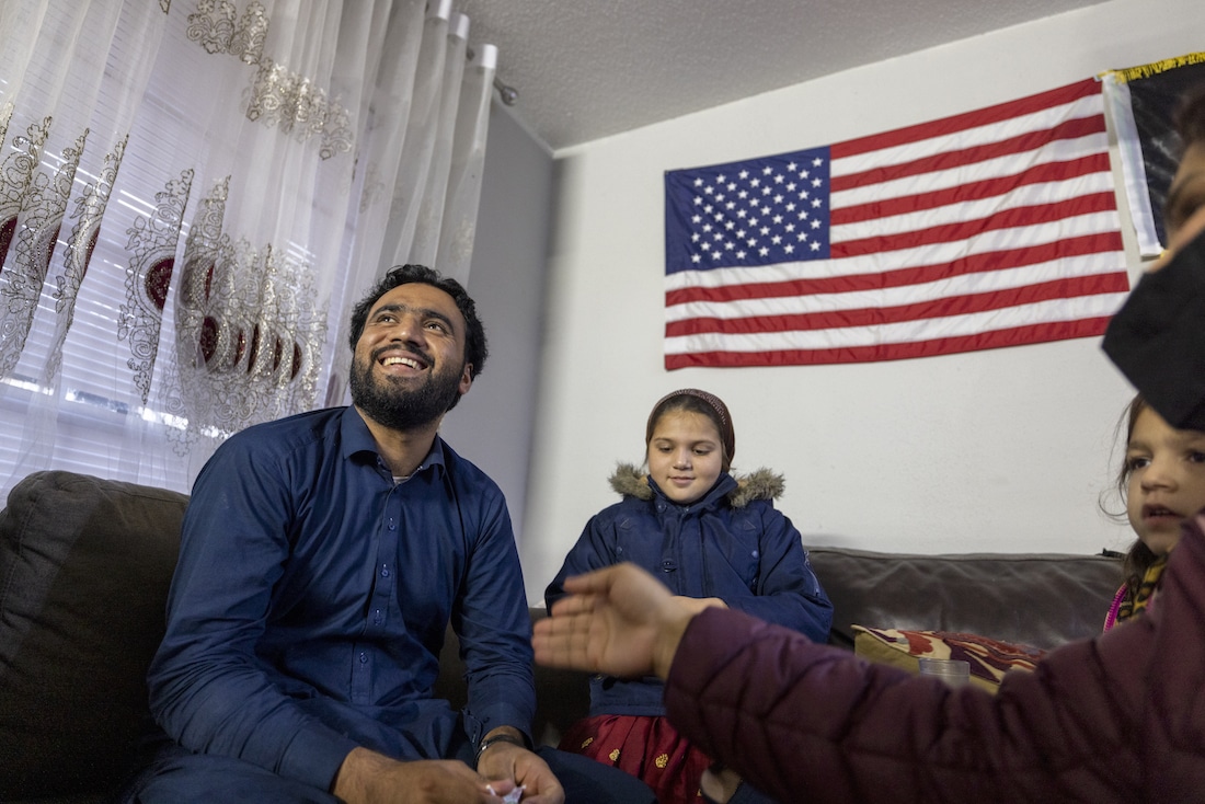 Man and daughter sitting in front of American flag