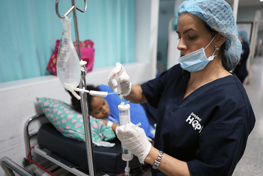 Nurse administering medicine through an IV.