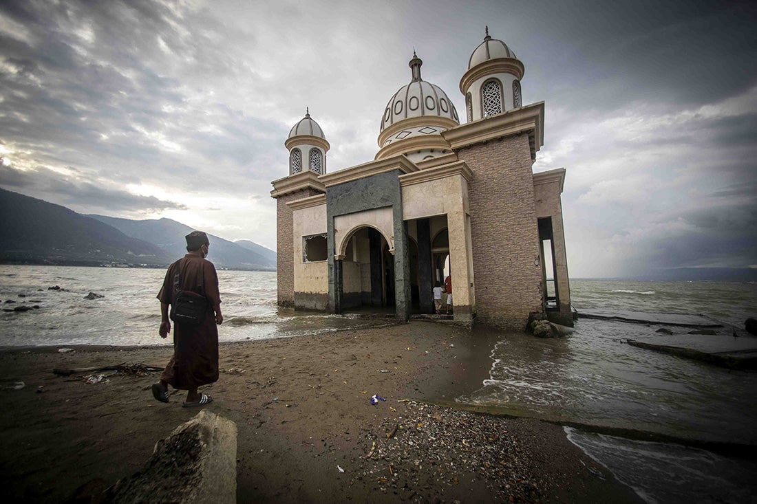 man walking to temple in water