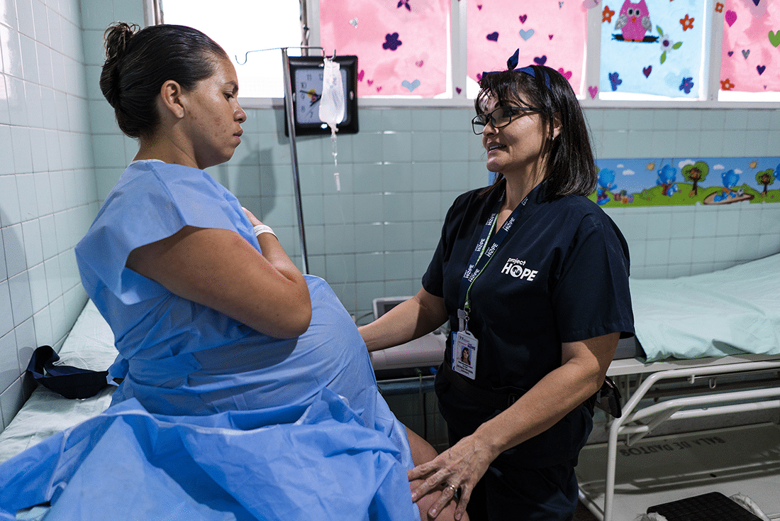 pregnant person in hospital with Project HOPE staff