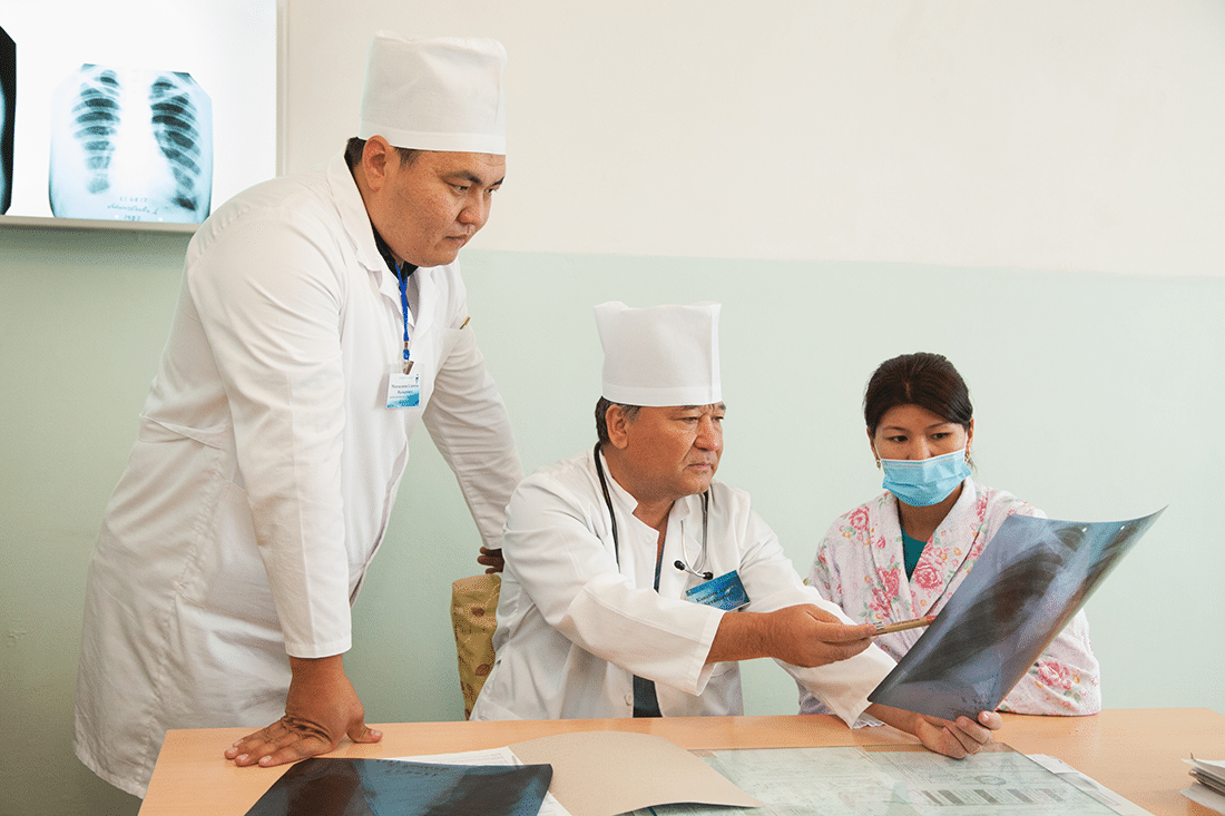 Three medical staff reviewing an x-ray