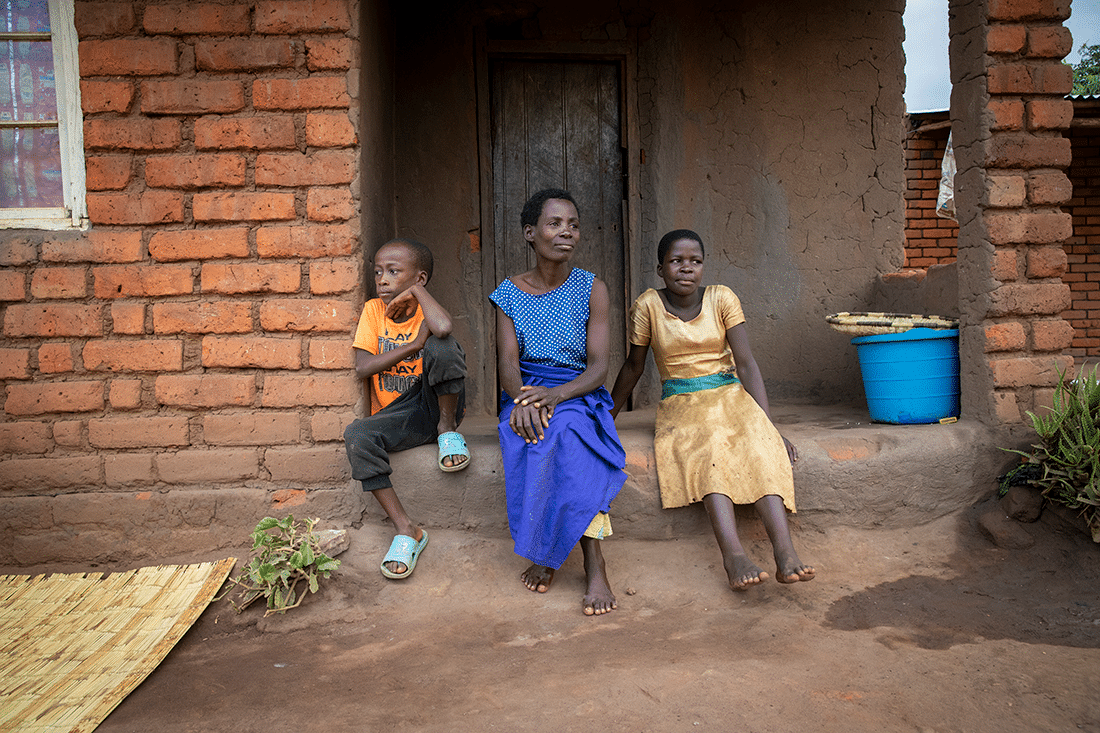 Mother and two children in front of house