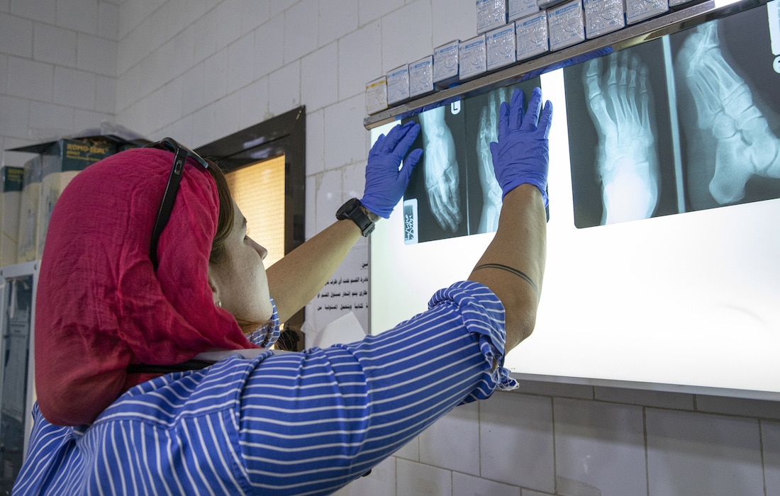 medical staff checks z-rays of patient's foot and hand