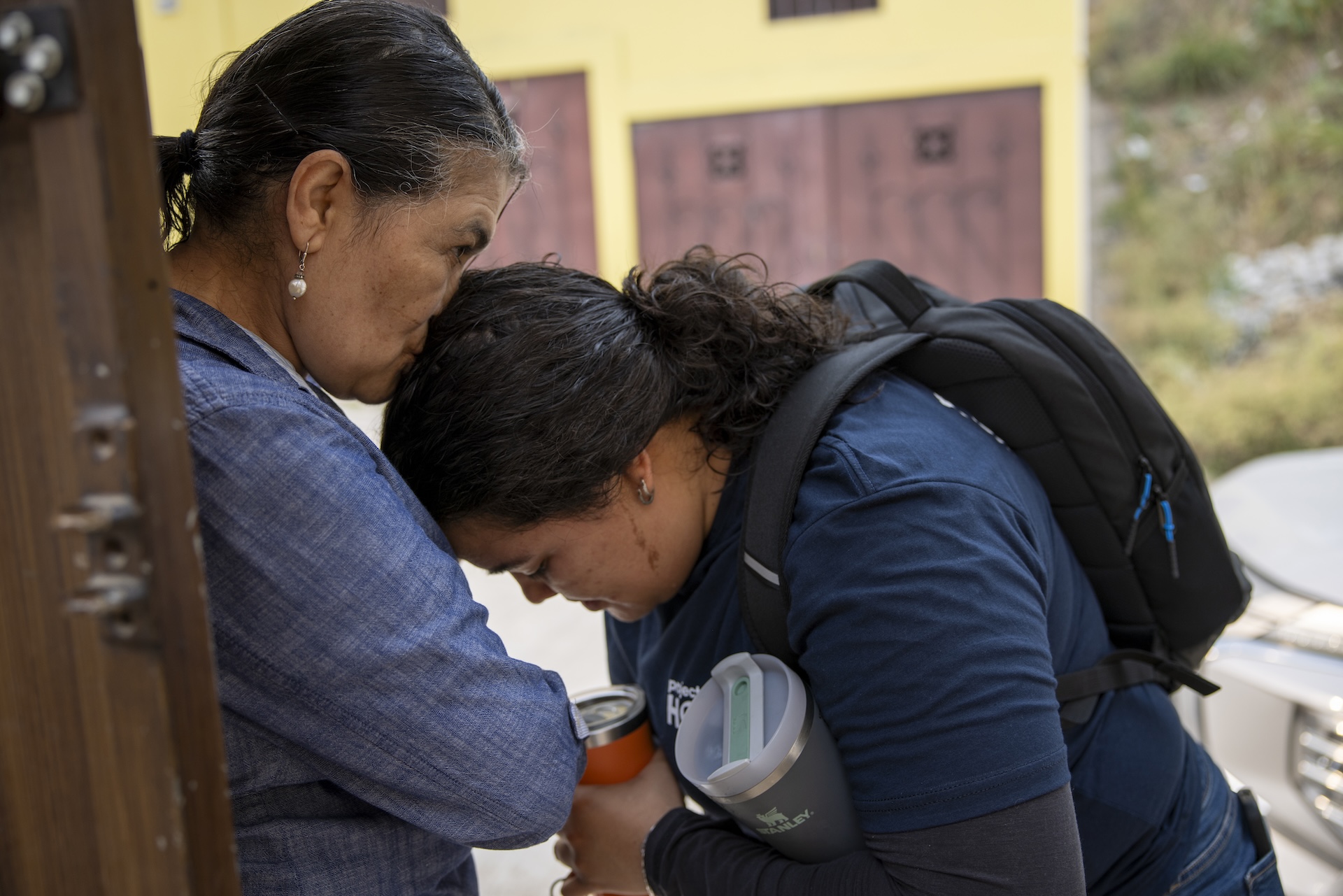 Two women, mother and daughter, embracing before work