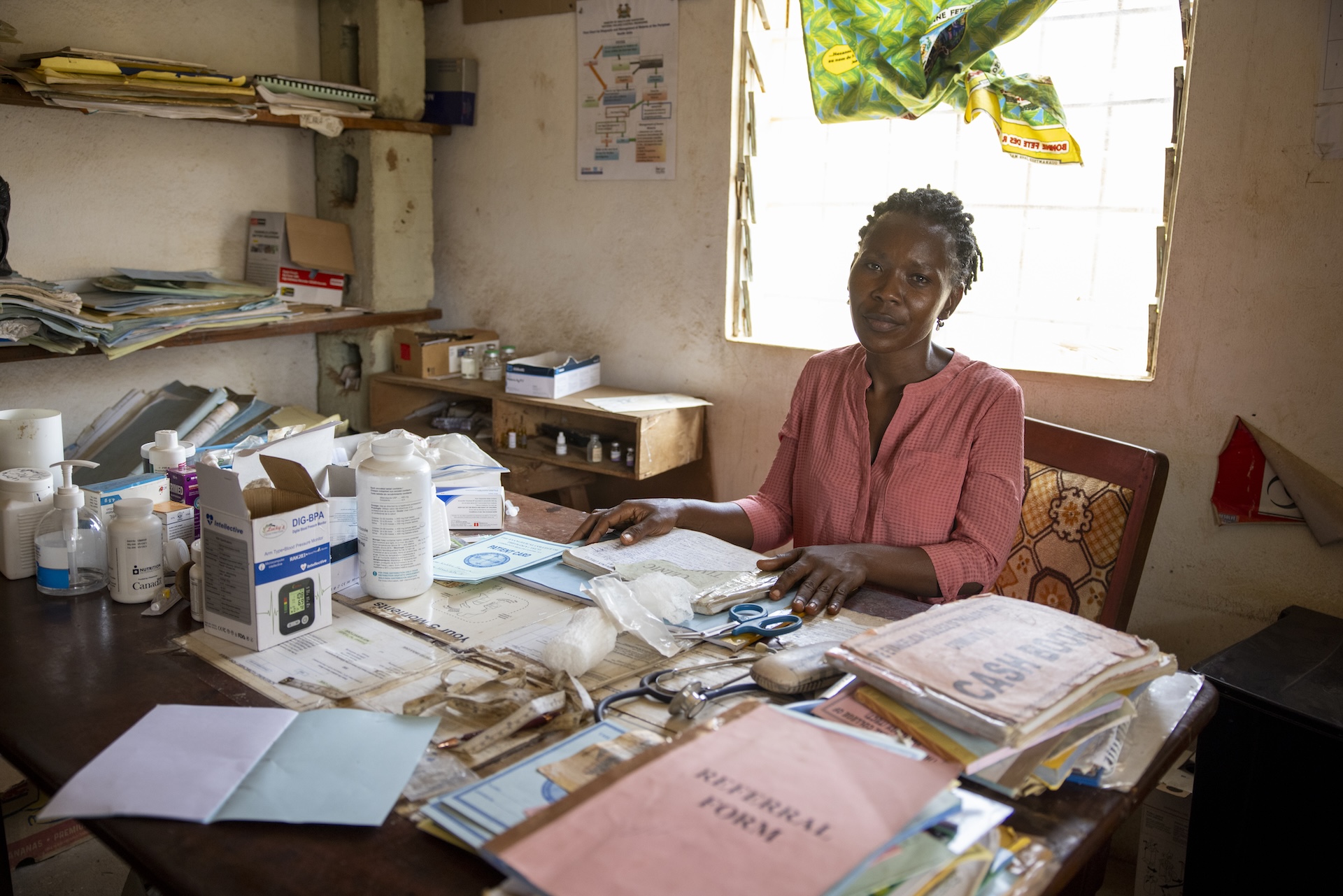 woman sitting at desk with medical paperwork