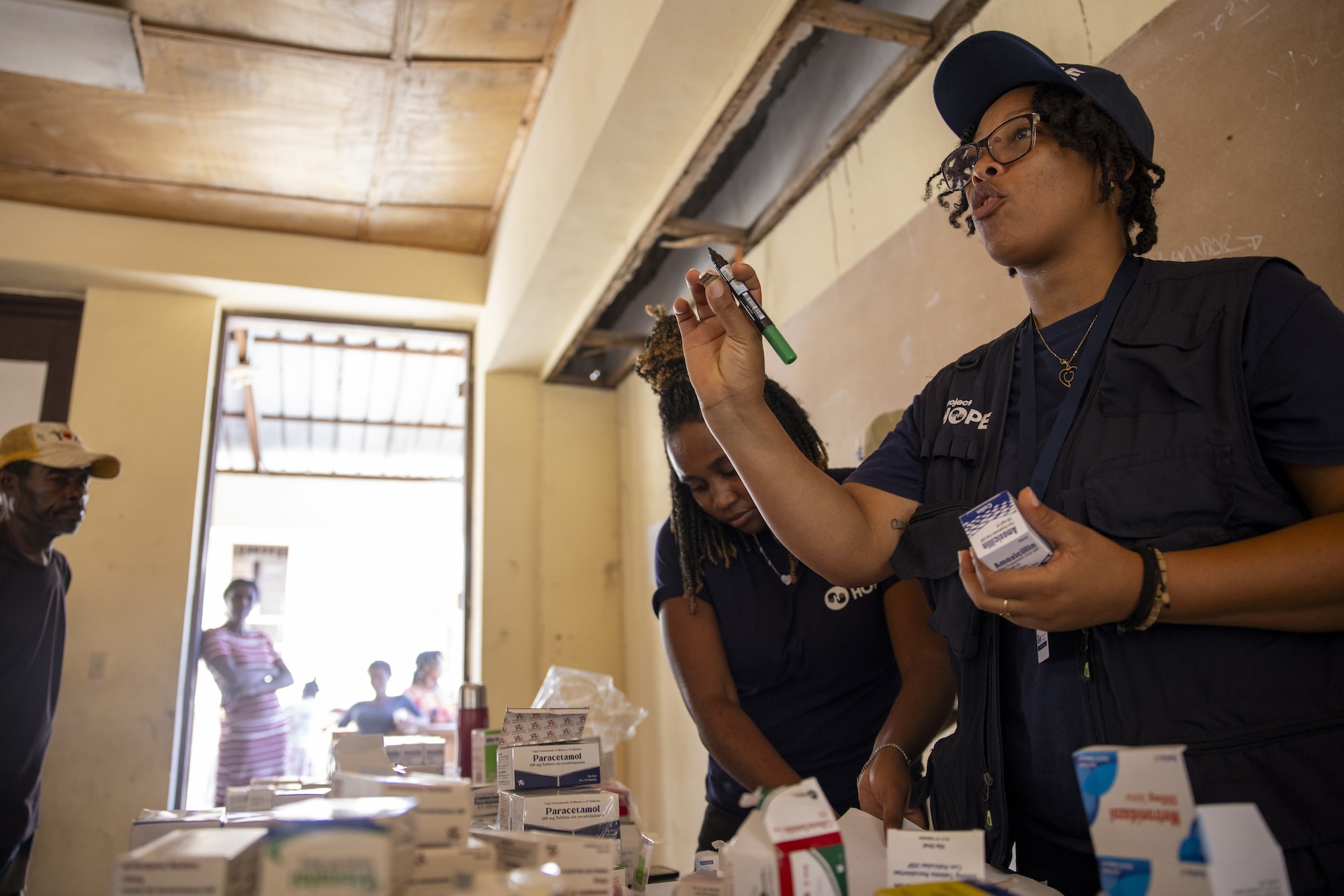 woman in Project HOPE gear goes through medicine in Haiti