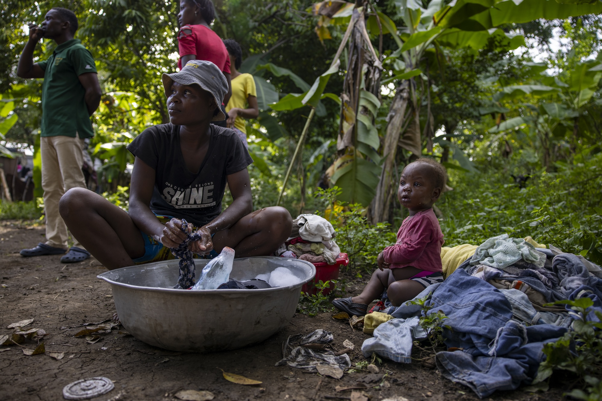 mother and child cleaning clothes in Haiti